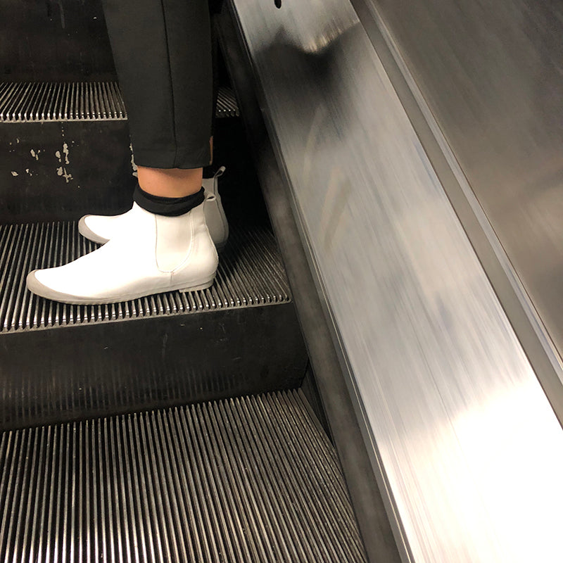 White Chelsea Boots on an escalator