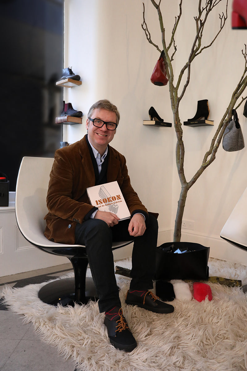 Scandinavian owner of Skandium, Magnus Englund with his book 'Isokon and the Bauhaus in Britain' wearing Tracey Neuls shoes