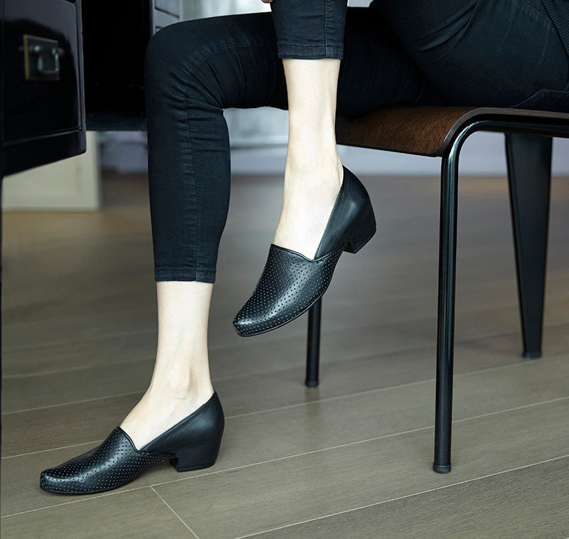 Black slip on loafers in perforated calf leather by designer Tracey Neuls