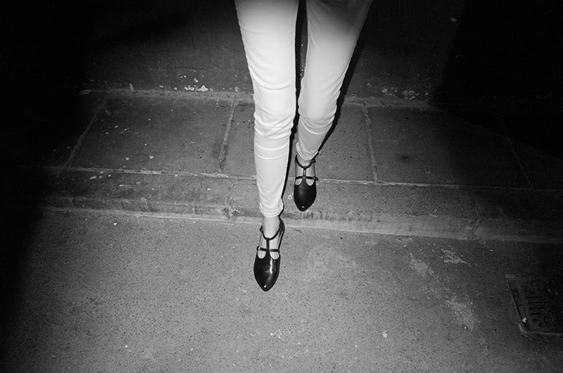 night flash black and white photography of a woman's legs wearing Tracey Neuls designer black leather tbar flat shoes